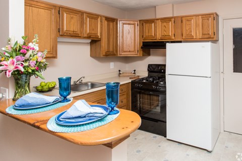 A kitchen with wooden cabinets and a white refrigerator.