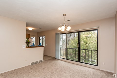 A spacious room with a balcony and a chandelier.