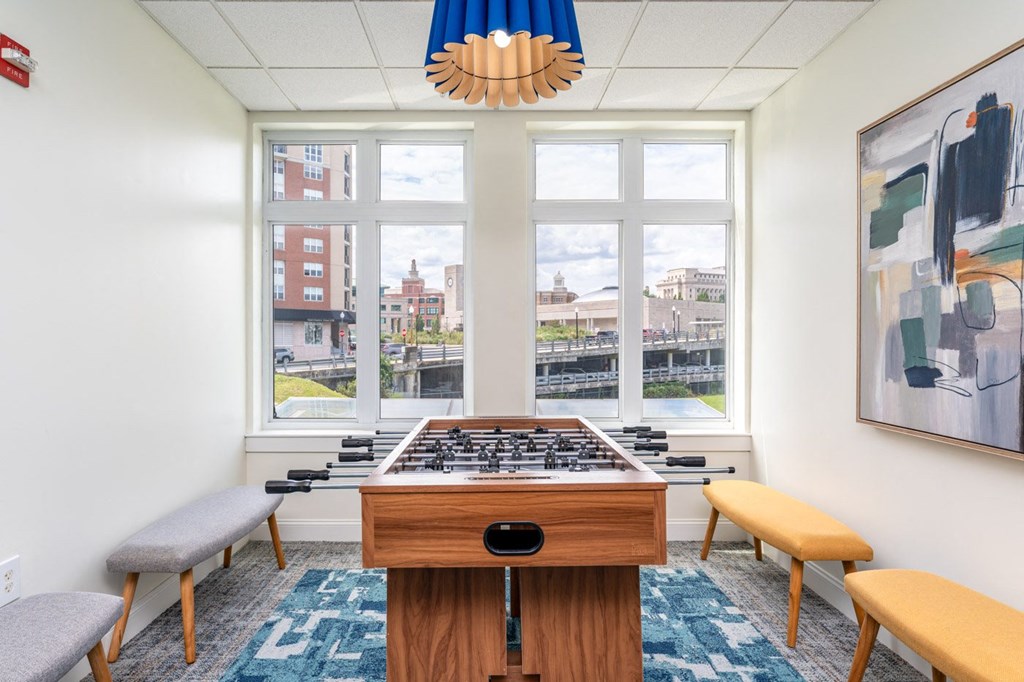 a room with a foosball table and a view of the city