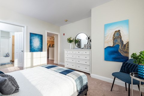 a bedroom with a white bed and a white dresser