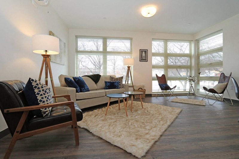 a living room with a couch and chairs and a rug