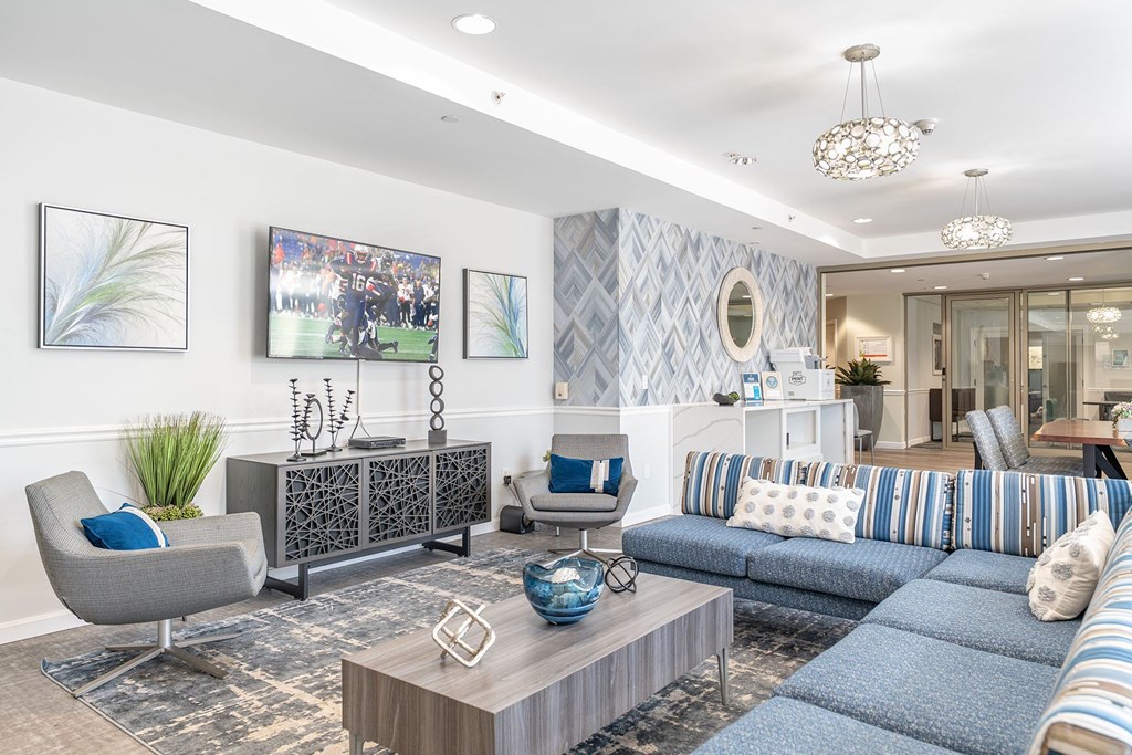 Parkside Commons community room with a grey armchair, a wooden coffee table, and a blue sofa.
