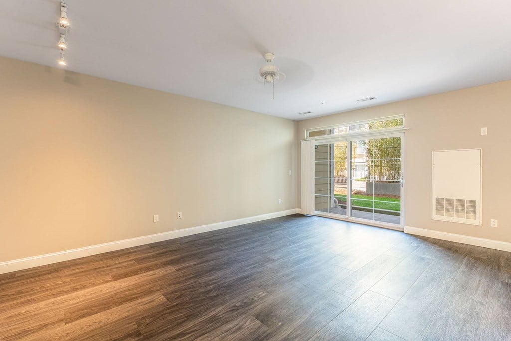 Parkside Commons vacant apartment room with wooden flooring and a ceiling fan.