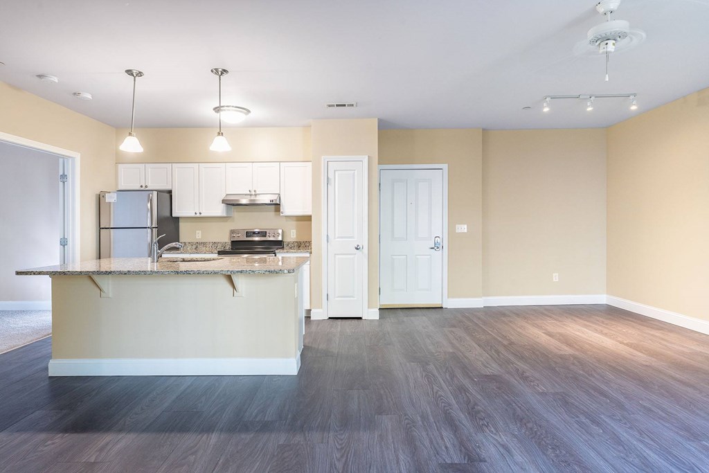 A kitchen with a refrigerator, sink, and cabinets.