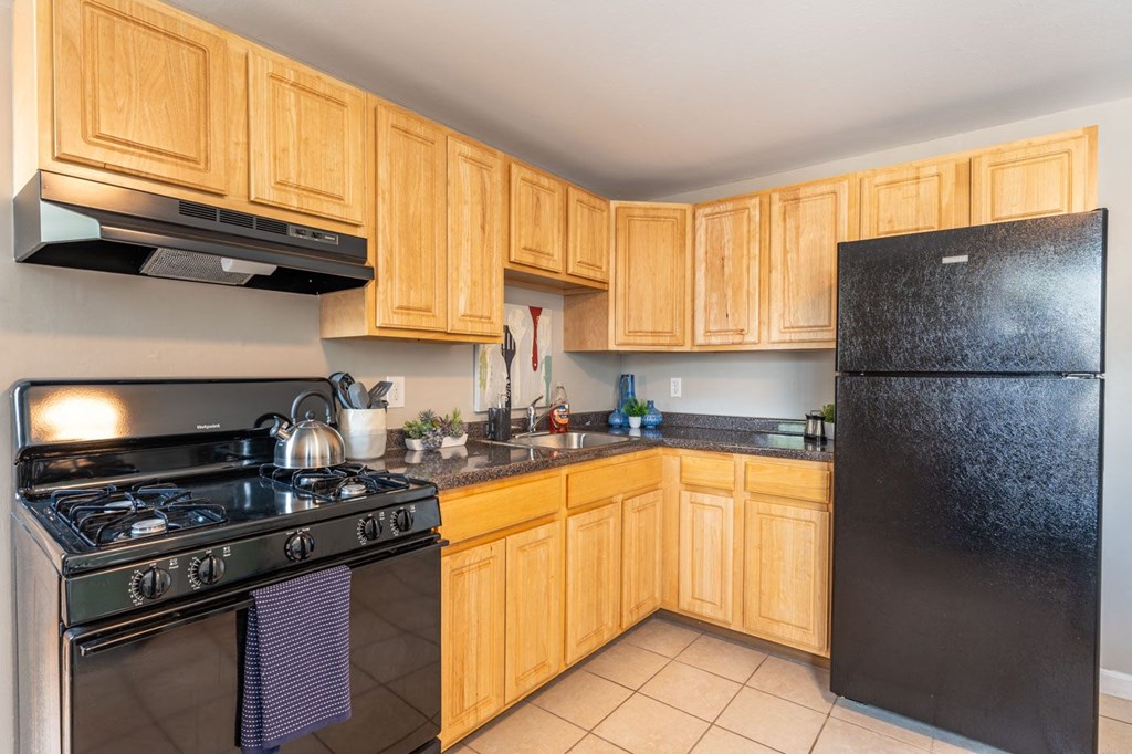 a kitchen with black appliances and wooden cabinets