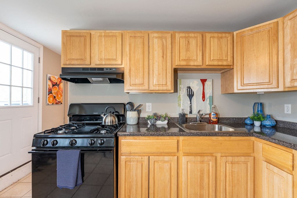 a kitchen with wood cabinets and a stove and a sink