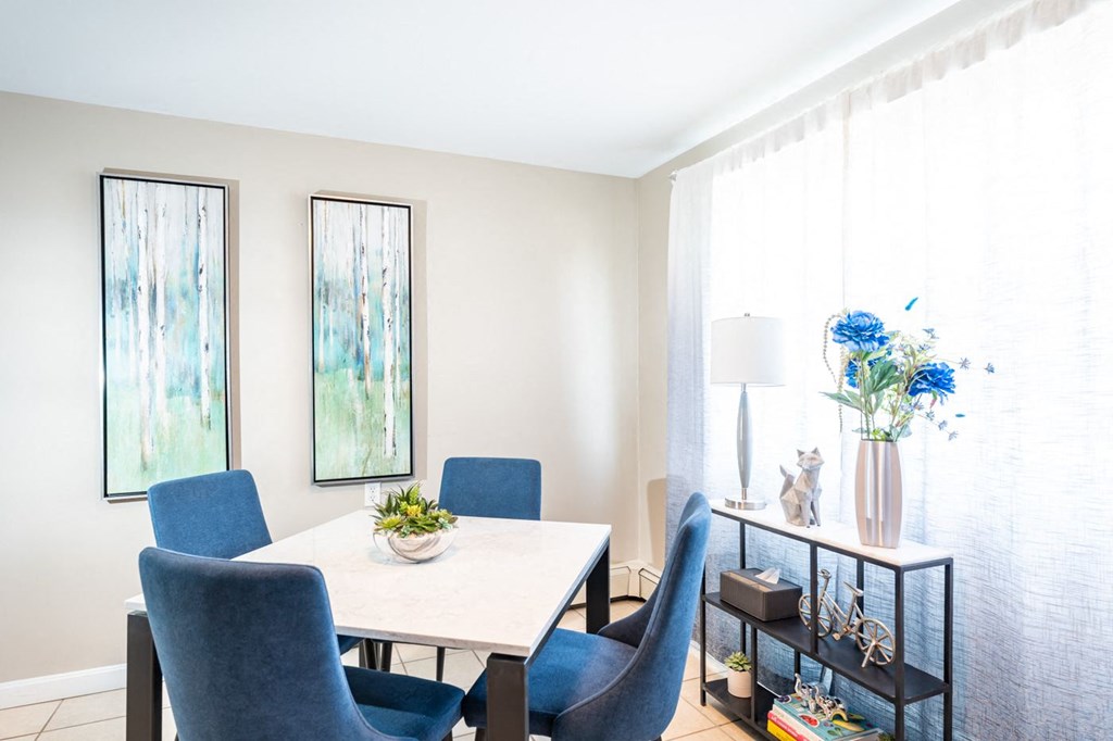 a dining room with a white table and blue chairs