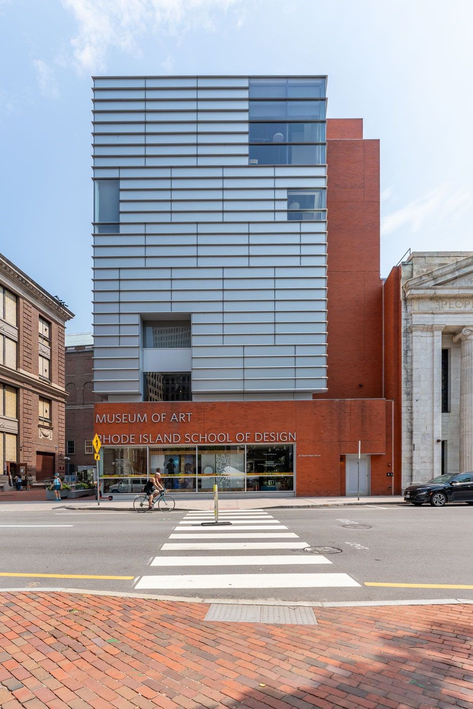 A modern building with a red brick building in front of it.