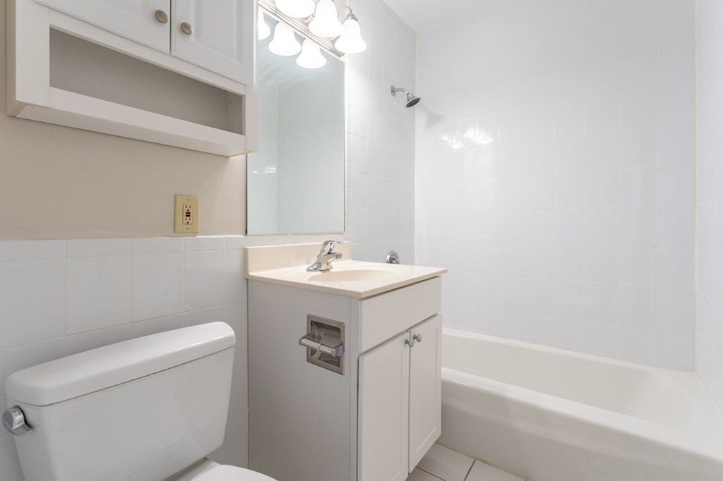 bathroom with bright vanity and white tiling