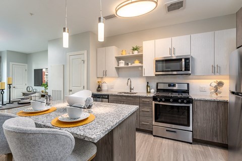 a kitchen with stainless steel appliances and a table with chairs