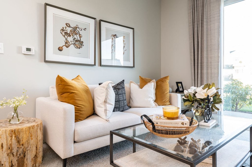 Model apartment common space couch with coffee table and paintings