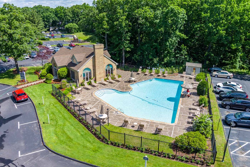 an aerial view of a swimming pool in front of a house