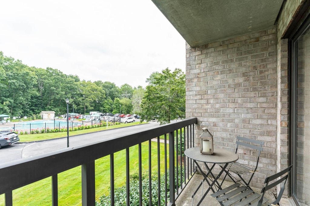 a balcony with two chairs and a table on a balcony