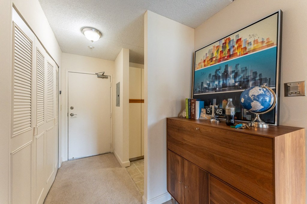 a hallway with a dresser and a door to a closet and a hall way