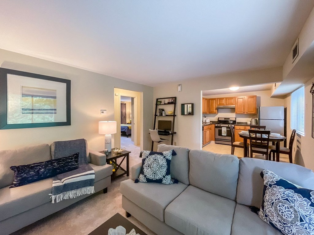 model apartment living space with couch and kitchen in background