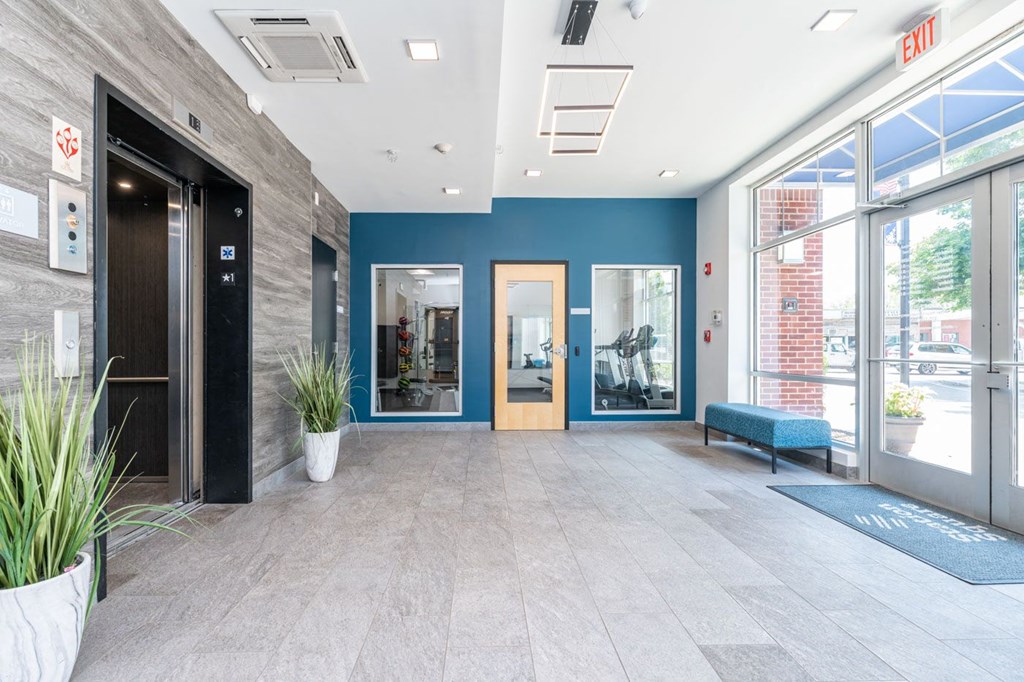 a large lobby with a bench and glass doors