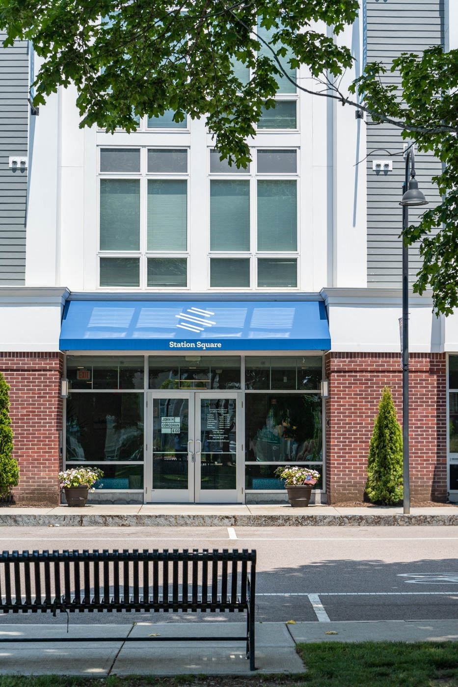 a bench in front of a building with a blue awning