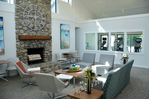 a living room with a stone fireplace and a table with chairs