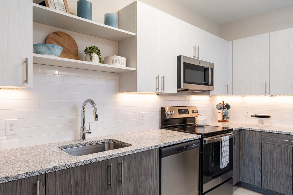 The Curtis kitchen with granite counters, electric range, stainless appliances