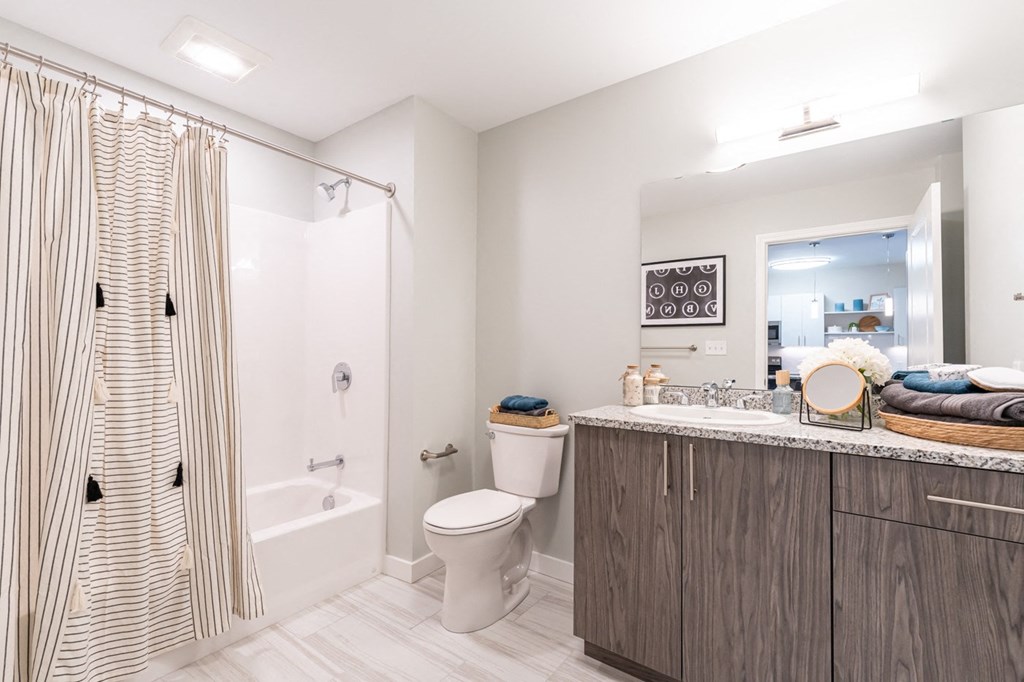 The Curtis model one bedroom apartment bathroom with tub and extra storage space