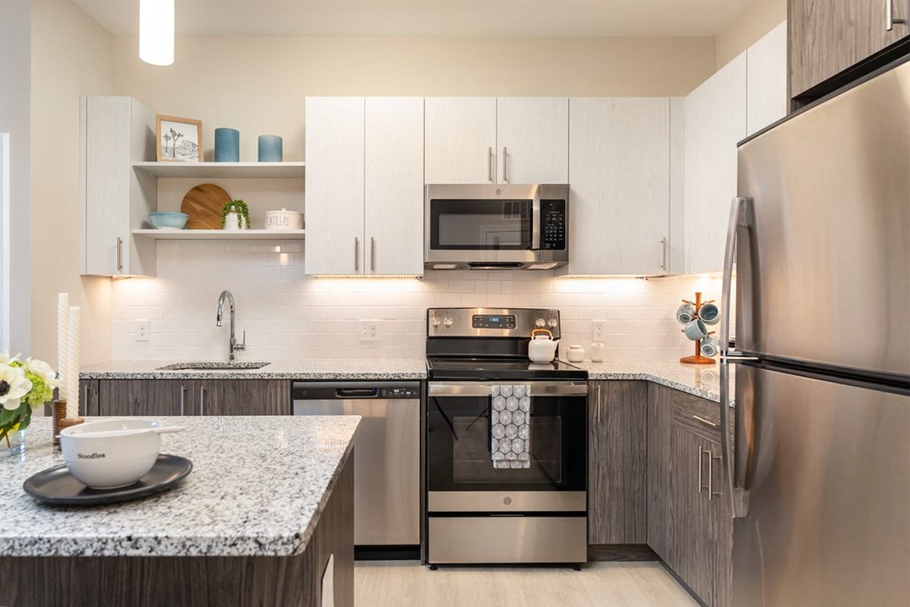 the curtis apartments with white cabinets and stainless appliances in kitchen