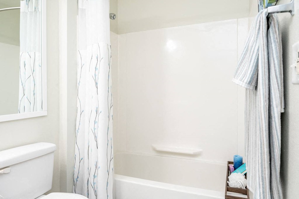 a white bathroom with a shower and a toilet