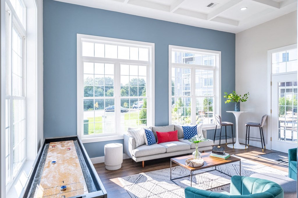 a view of the clubhouse with seating and shuffle board at the sto in stoughton