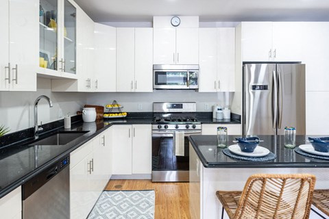 a modern kitchen with white cabinets and stainless steel appliances