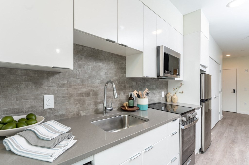 a kitchen with white cabinetry and a stainless steel sink at Union 346 Apartments in Somerville, MA