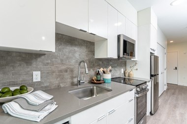 a kitchen with white cabinetry and a stainless steel sink at Union 346 in Somerville, MA