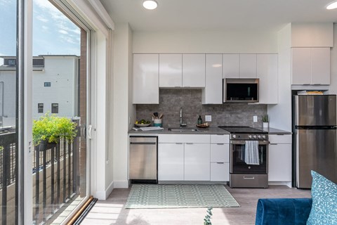 a small kitchen with white cabinets and stainless steel appliances