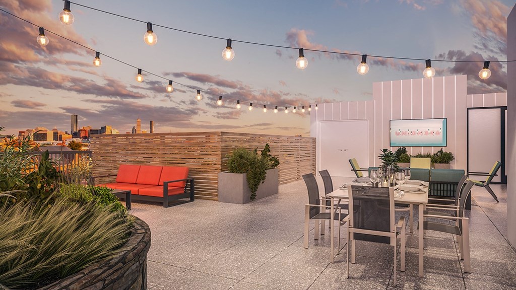 a rendering of a rooftop patio with a sunset in the background at Union 346 Apartments, Somerville, MA
