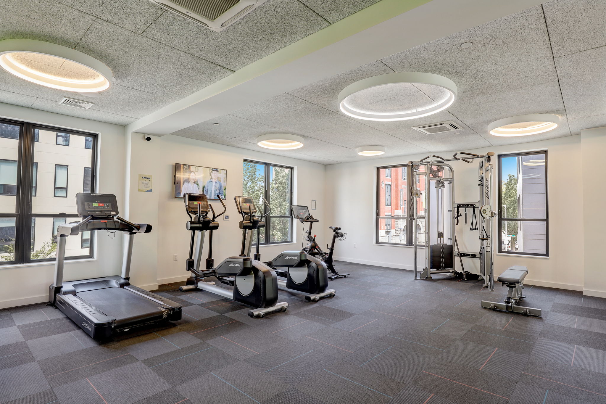 Fitness center with cardio equipment and cable machine.