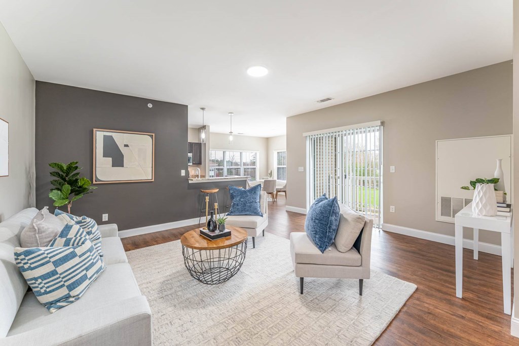 A living room with a grey couch, a white chair, and a coffee table.