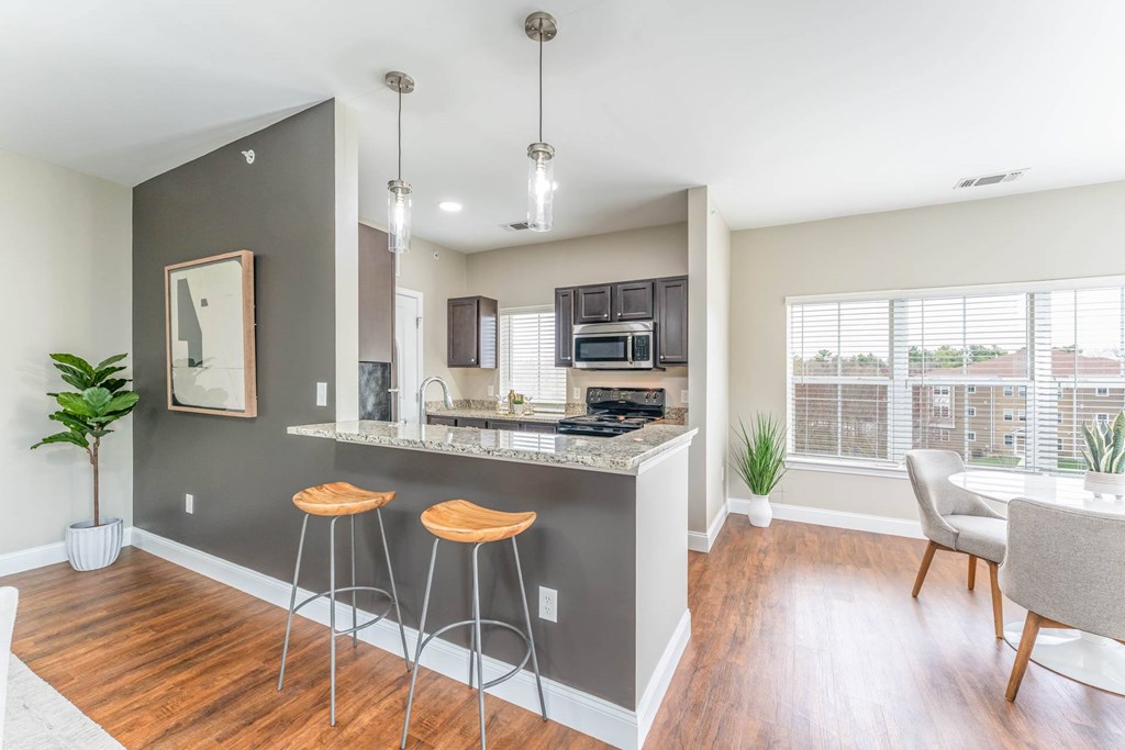 A kitchen with a bar area and a dining table.