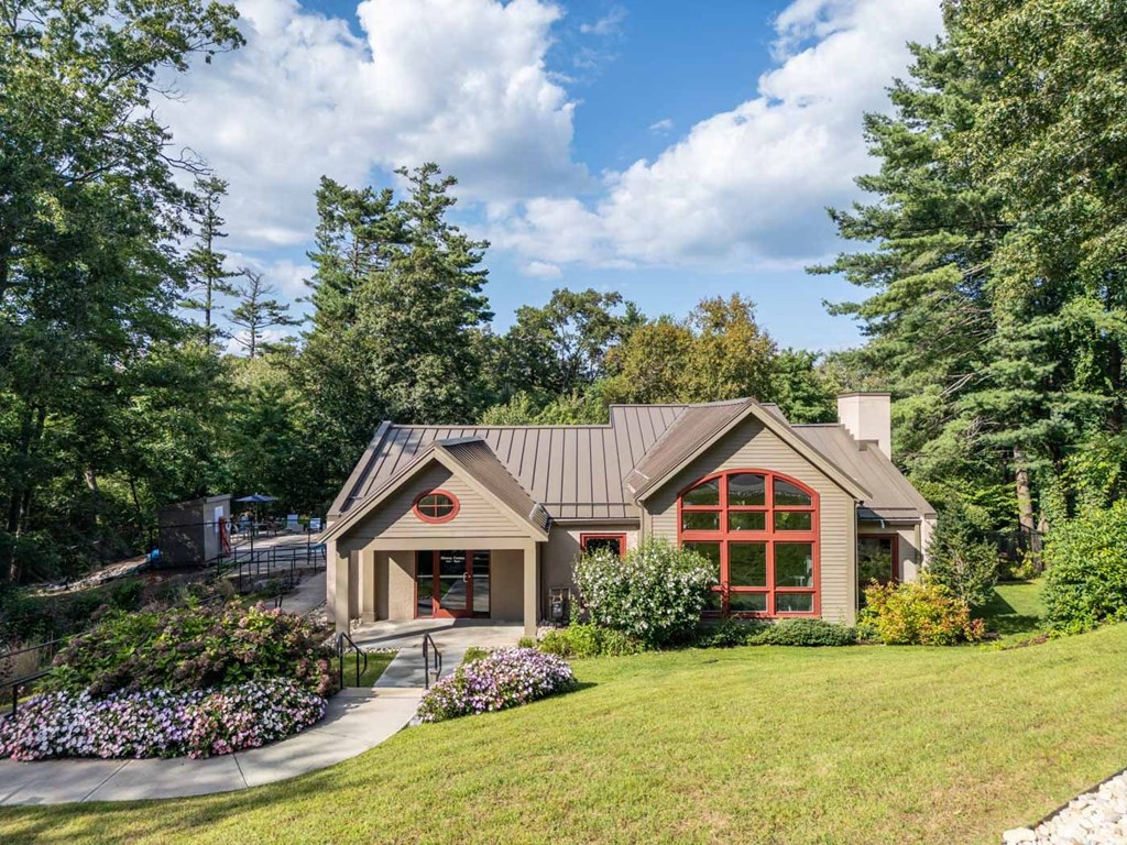 the front of a house with a lawn and trees
