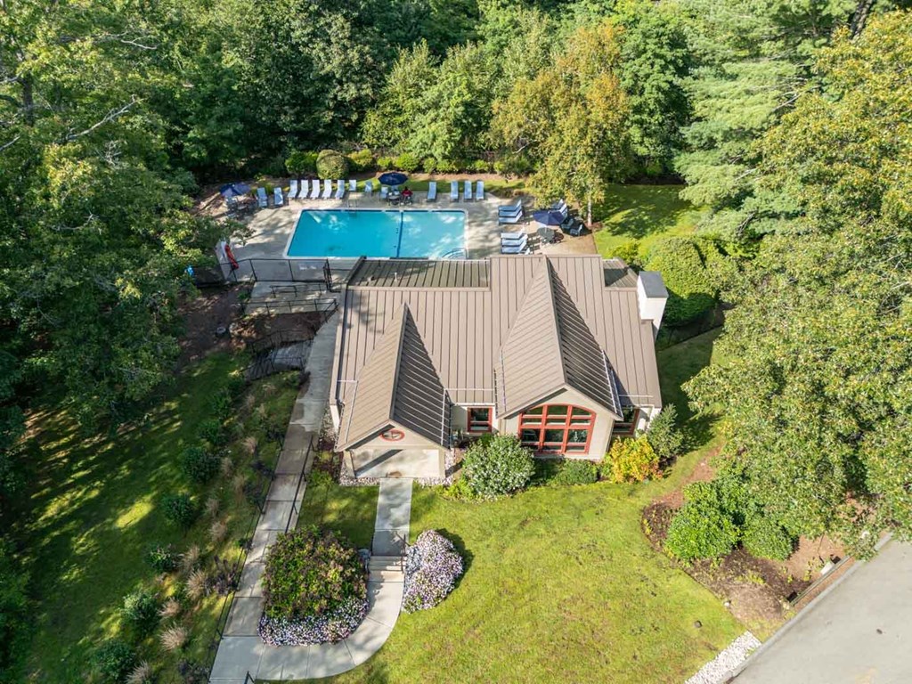 an aerial view of a house with a swimming pool and a yard with chairs
