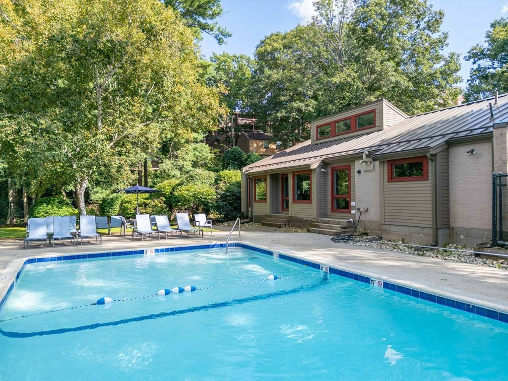 a swimming pool in front of a house with a pool