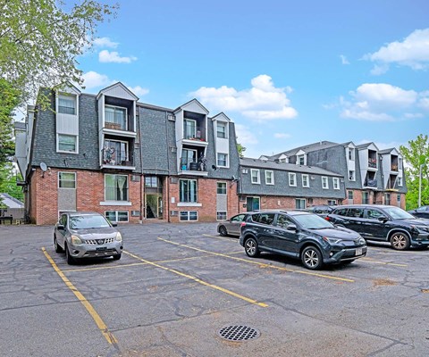 A parking lot with cars and a building in the background.