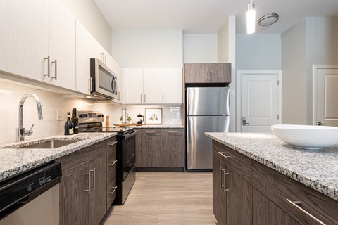 a large kitchen with granite counter tops and stainless steel appliances