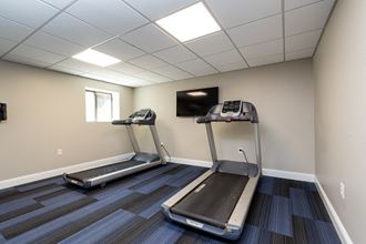 Quincy Commons gym with treadmills and a tv