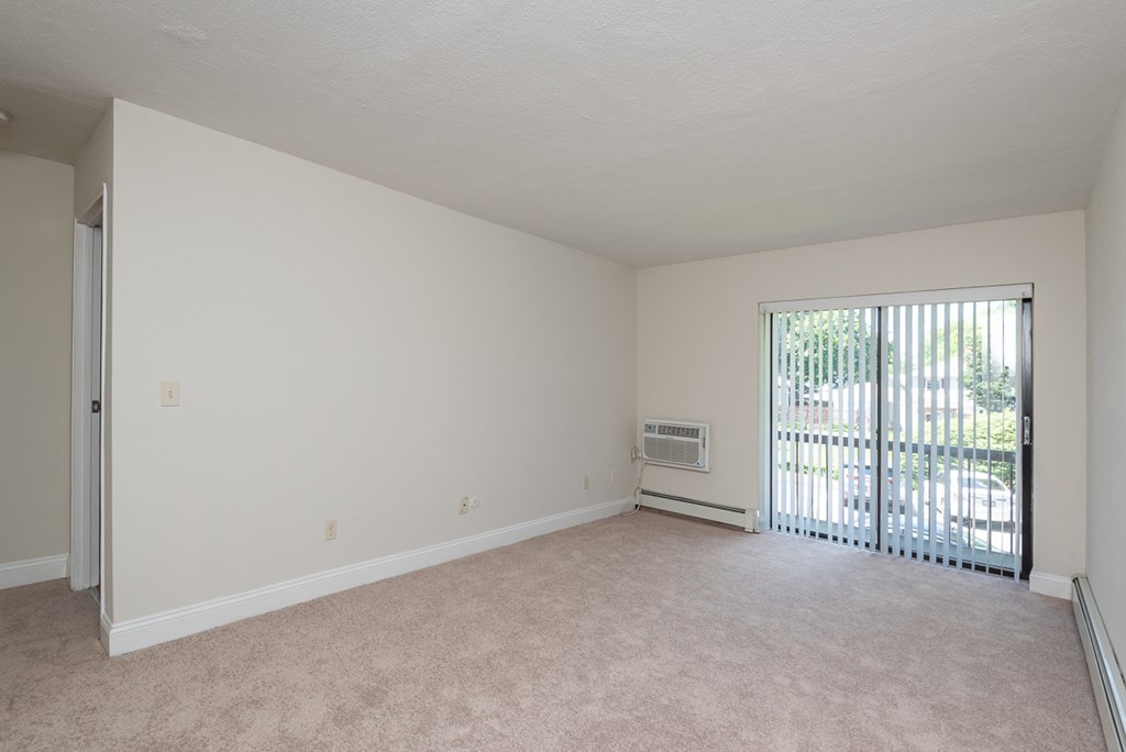 Quincy Commons one bedroom apartment with plush carpeting and balcony