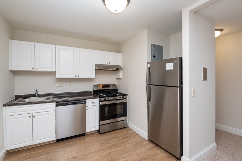 Quincy commons kitchen with white finishes, high quality flooring, and stainless steel appliances