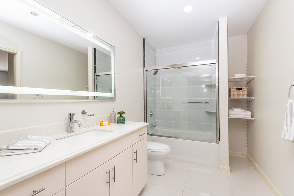The sto bathroom with granite flooring, glass shower door, and high quality finishes