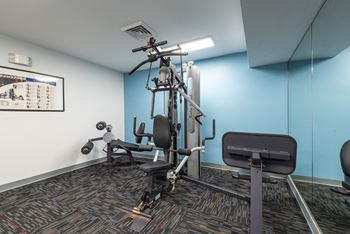 a gym with exercise equipment and a blue wall