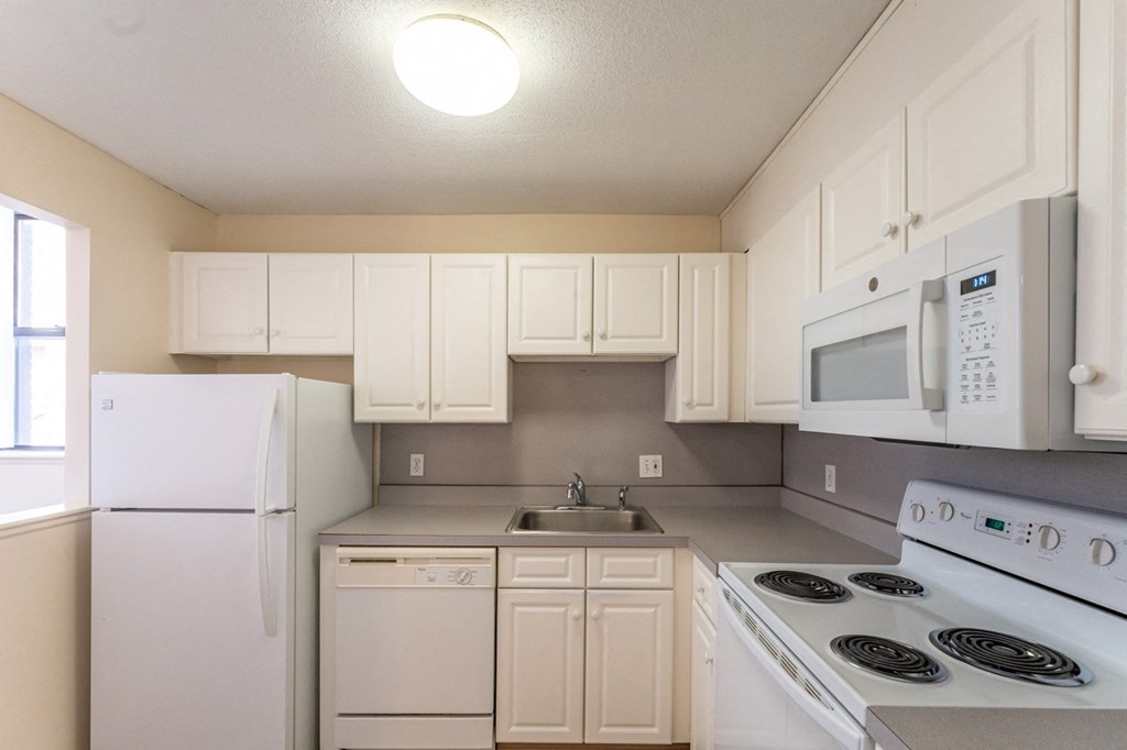 a kitchen with white appliances and white cabinets