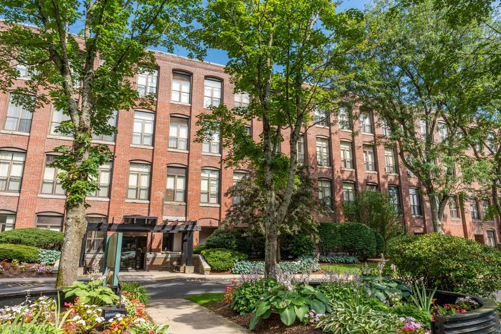 a brick building with a garden in front of it
