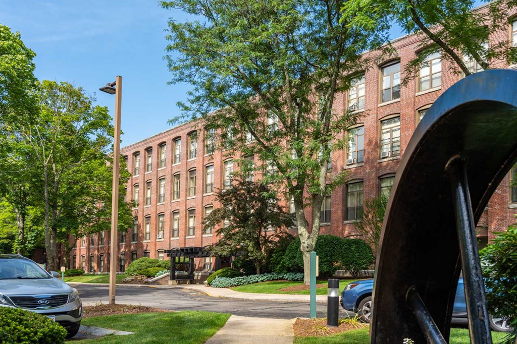 a large brick building with a sculpture in front of it