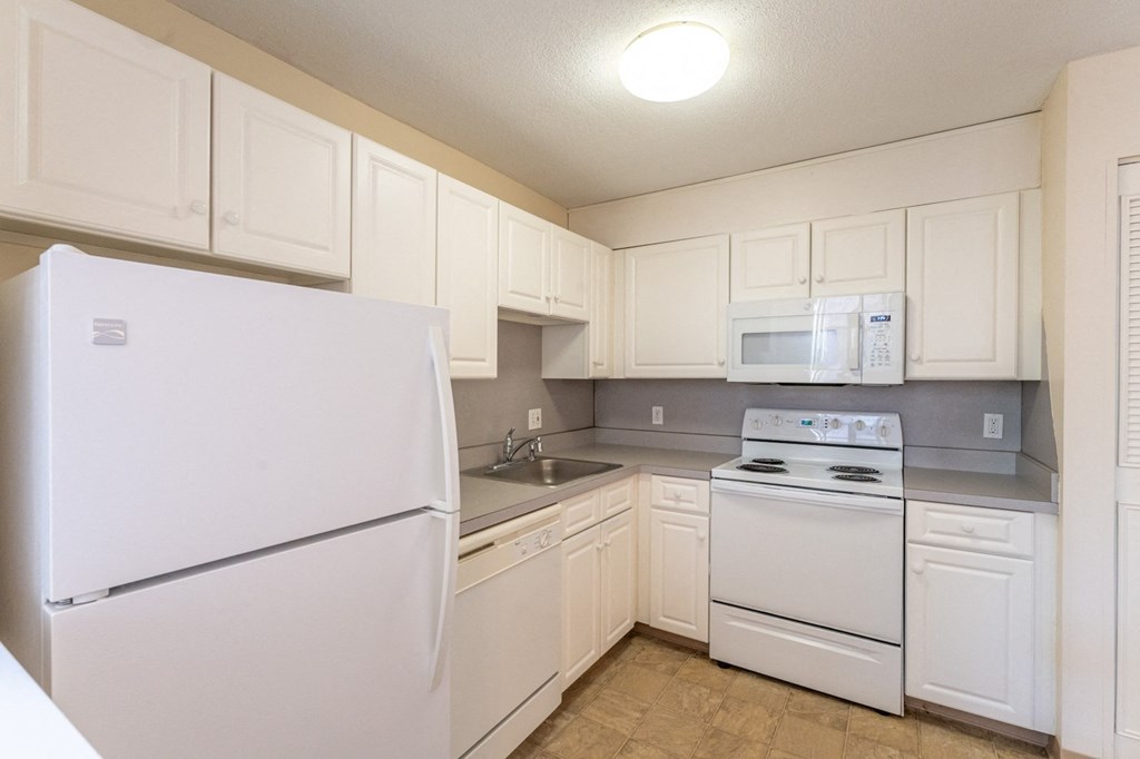 a kitchen with white appliances and white cabinets