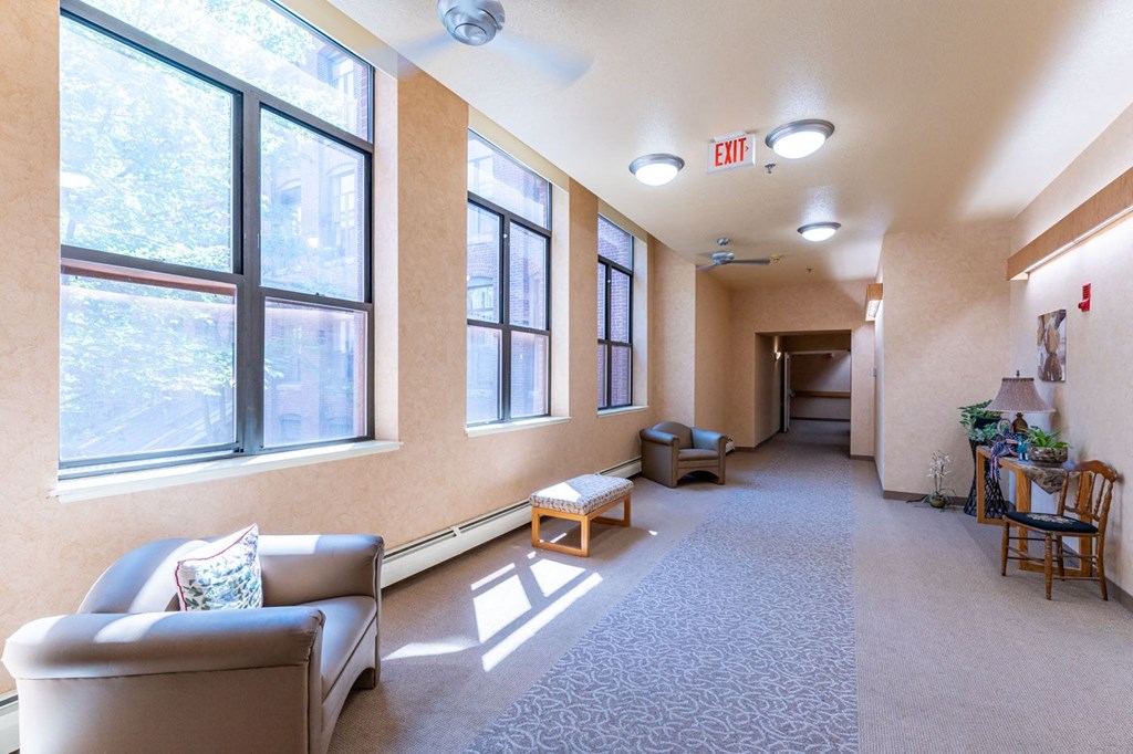 a hallway with couches and chairs and large windows